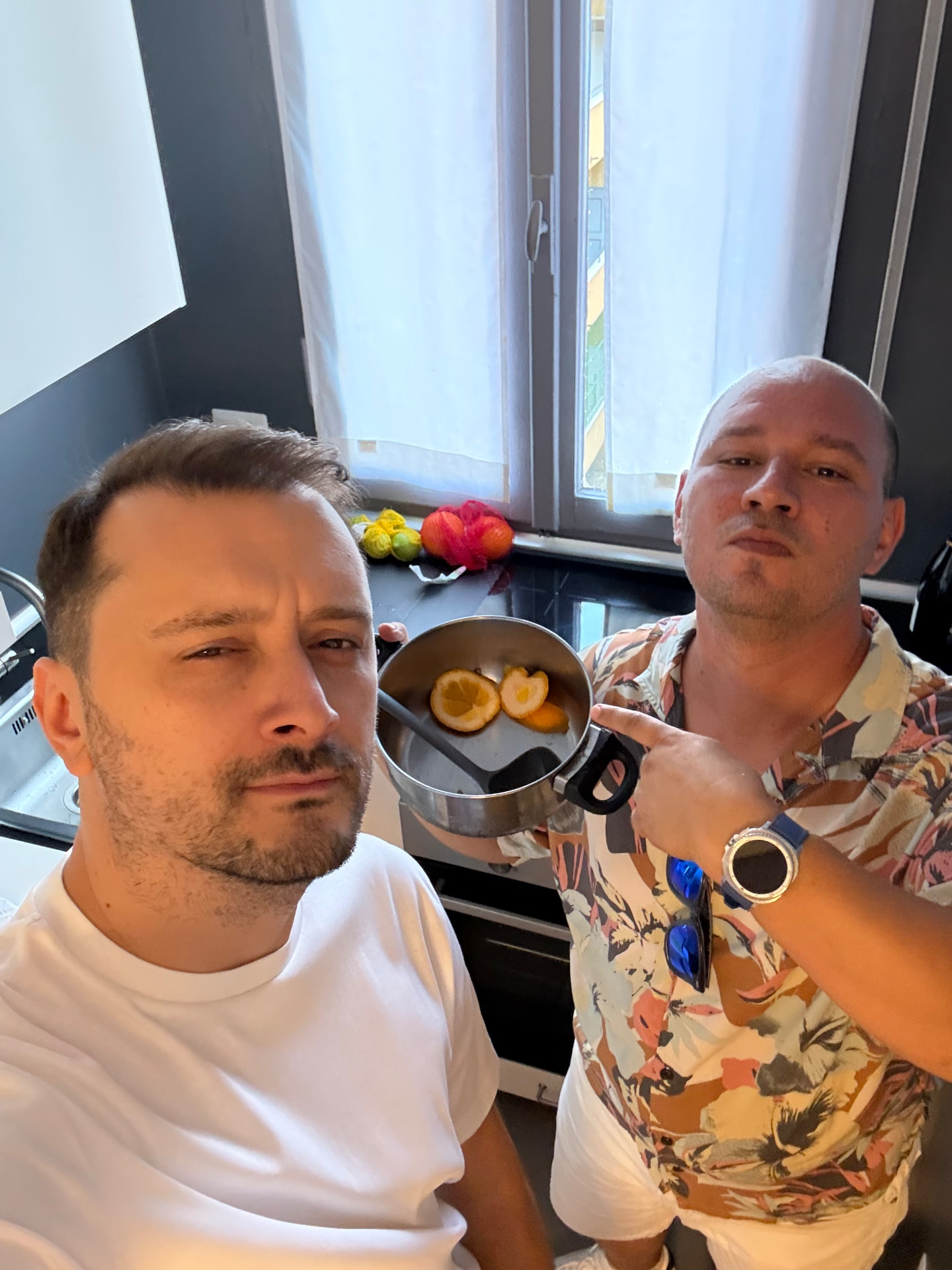Adi and Bala presenting a saucepan of lemons in a kitchen