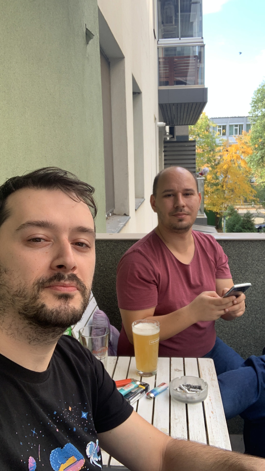 Adi and Bala relaxing with a beer on a balcony